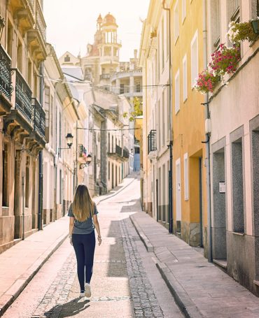 Young woman walking by the streets of Ribadeo, Galicia